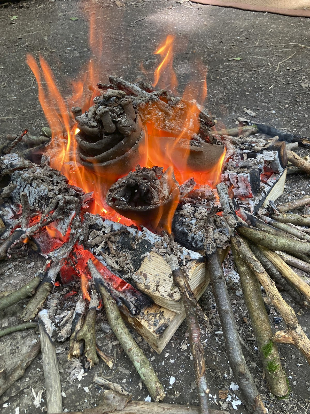 A fire burning with wild pottery nestled in it